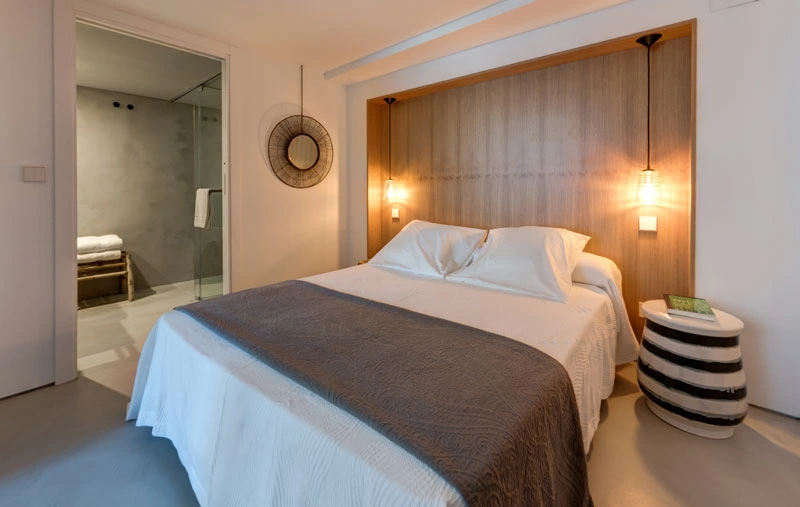 Camera da letto con testiera in legno caldo e bagno en suite nel loft con soppalco a Siviglia