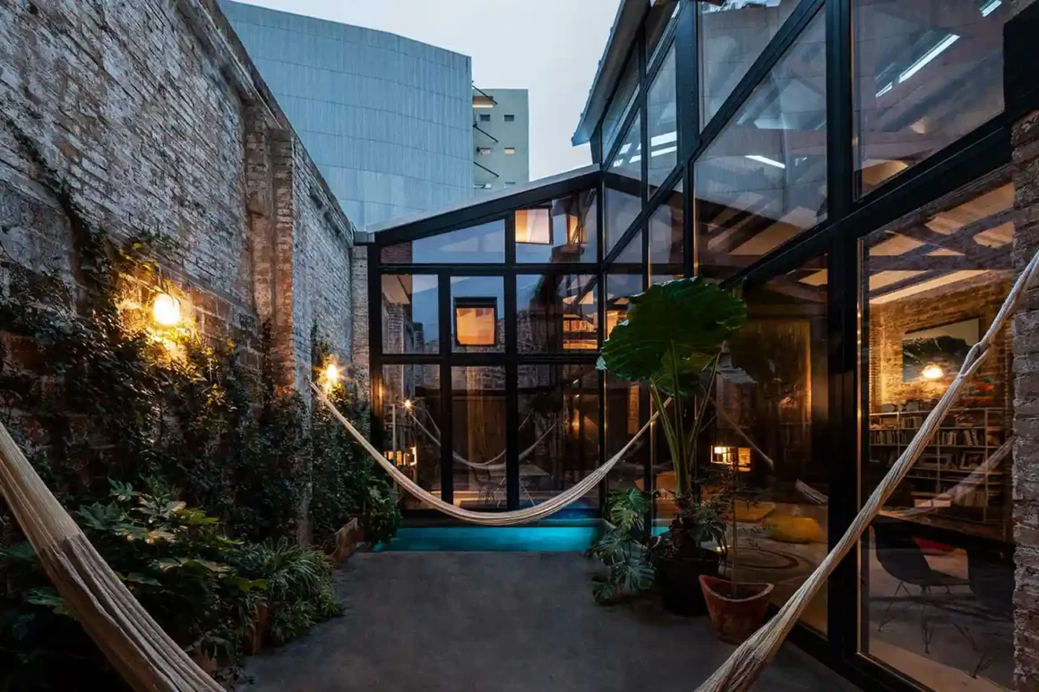 Patio interno con vasca d'acqua e amache nel loft industriale Il Teatro a Barcellona, progetto di Studio Cavadal