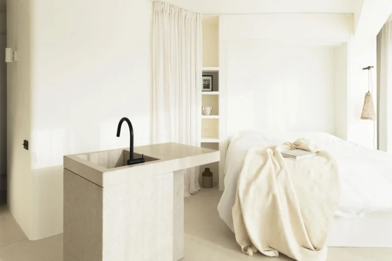 cucina e zona notte minimalista con materiali naturali e toni neutri