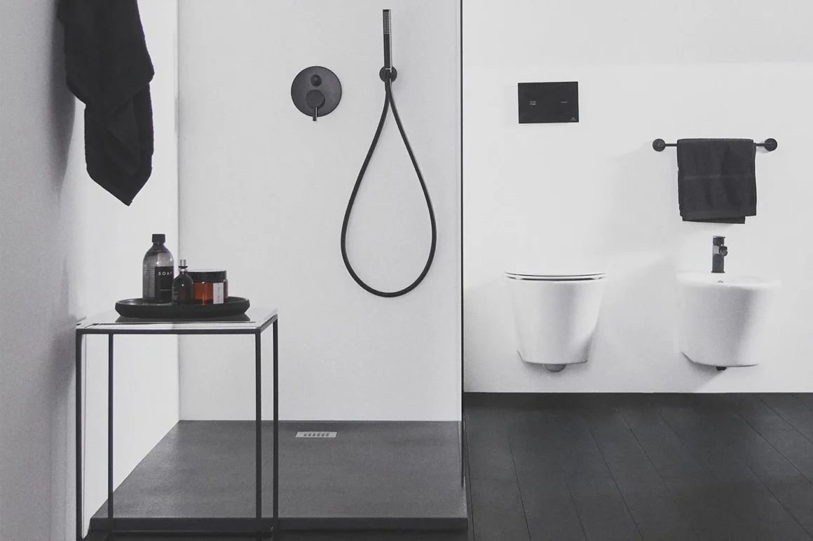 Bagno nero e bianco moderno con rubinetteria nera, piatto doccia antracite e sanitari bianchi a parete, collezione Ideal Standard