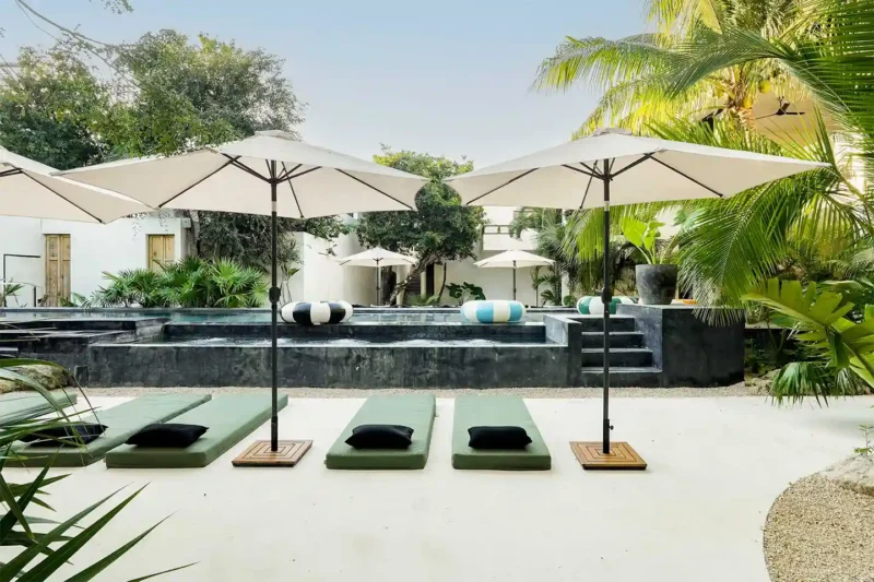 Area piscina del Boutique Hotel 16 Tulum con lettini e ombrelloni