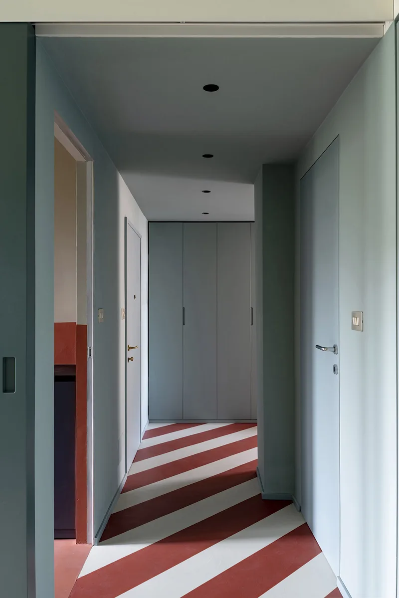Corridoio con pavimento a righe rosse e bianche, progetto Atelierzero per rinnovare con il colore un appartamento di 60 mq a Milano