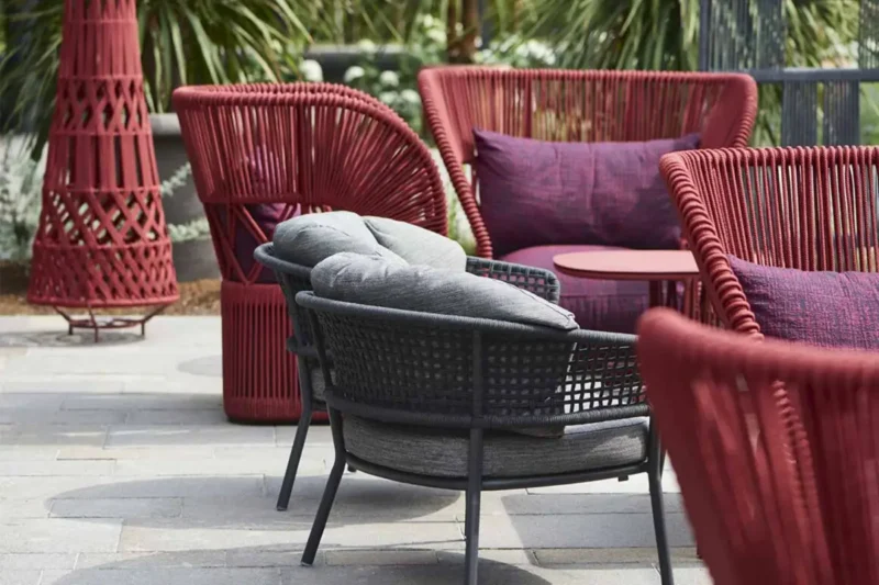 Sedute outdoor Talenti in rosso nell'area lounge del Manna Resort, hotel di design in Alto Adige