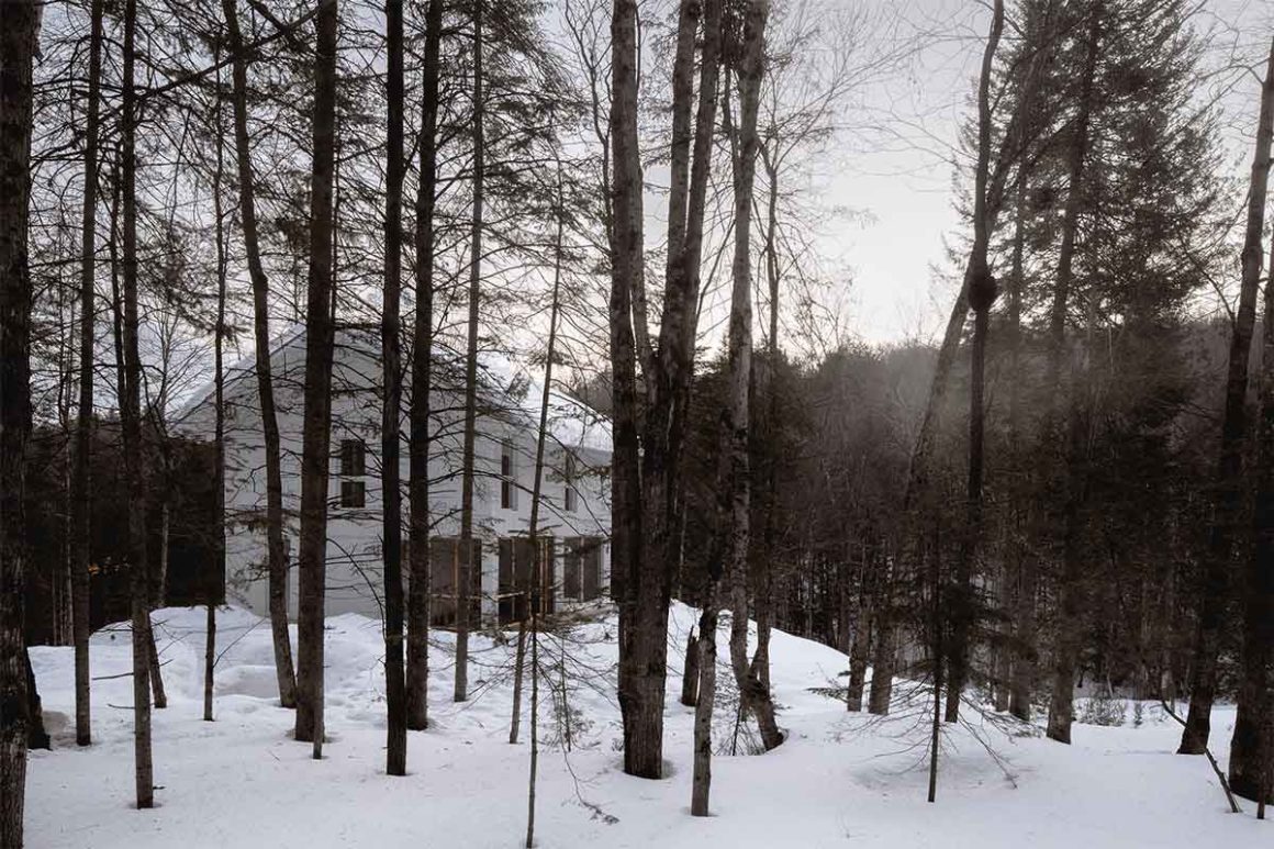 una casa bianca nel bosco innevato