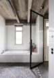 bagno in stile industriale con pavimento e soffitto in cemento