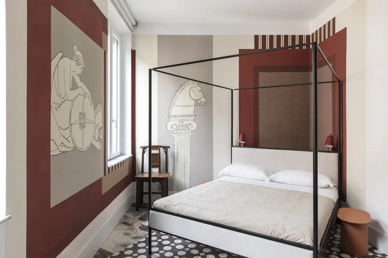 camera da letto con letto a baldacchino e carta da parati ispirata all'antica Roma