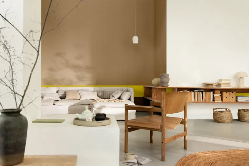 Soggiorno accogliente con parete terracotta e arredi naturali, tonalità tra le tendenze colori parei 2025