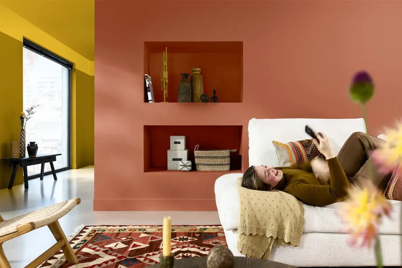 soggiorno dal look autunnale con parete terracotta e giallo speziato, colori pareti di tendenza