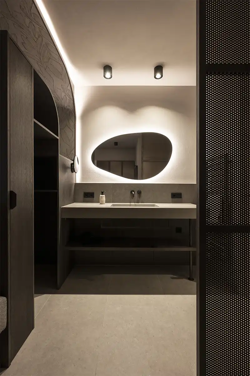 materiali naturali e specchio dalla forma organica dei nuovi appartamenti dell’Hotel Nutzhof firmati dallo studio NOA