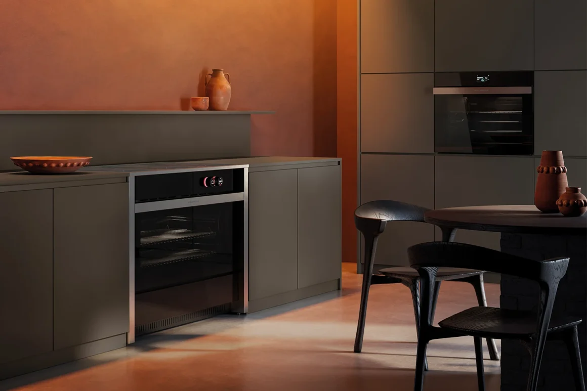 Cucina a libera installazione Aura di Glem Gas in ambiente living con illuminazione calda ambrata, zona cottura e area pranzo, design contemporaneo Made in Italy