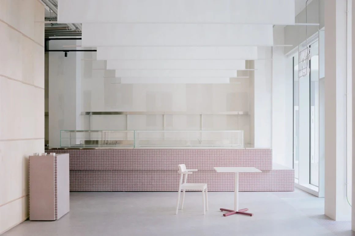 Pan Deli Milano Studio Wok – bancone rivestito in mosaico rosa antico con vetrina espositiva e pavimento in cemento