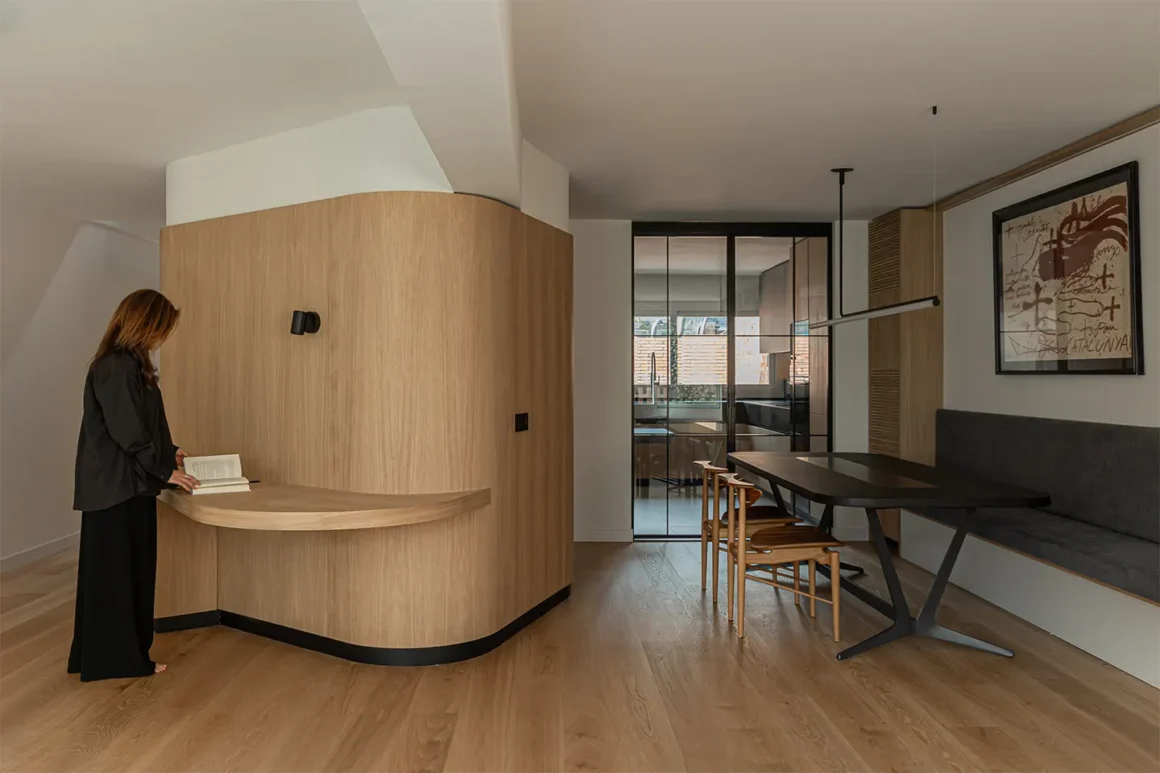 Casa AT di UNODE Estudio, ristrutturazione completa ad Aravaca Madrid: il volume curvo in rovere e la zona pranzo