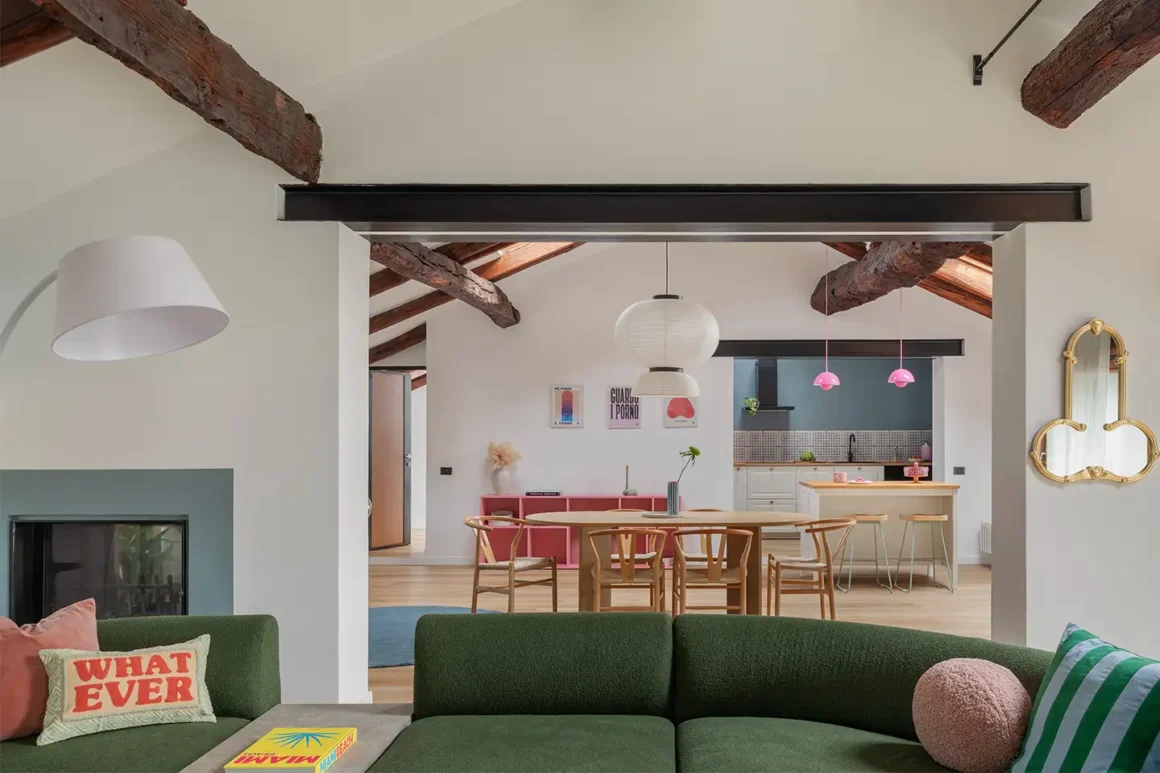 La casa colorata di Francesca Biella: open space con divano verde, travi a vista e cucina pop firmata Storie Design Studio