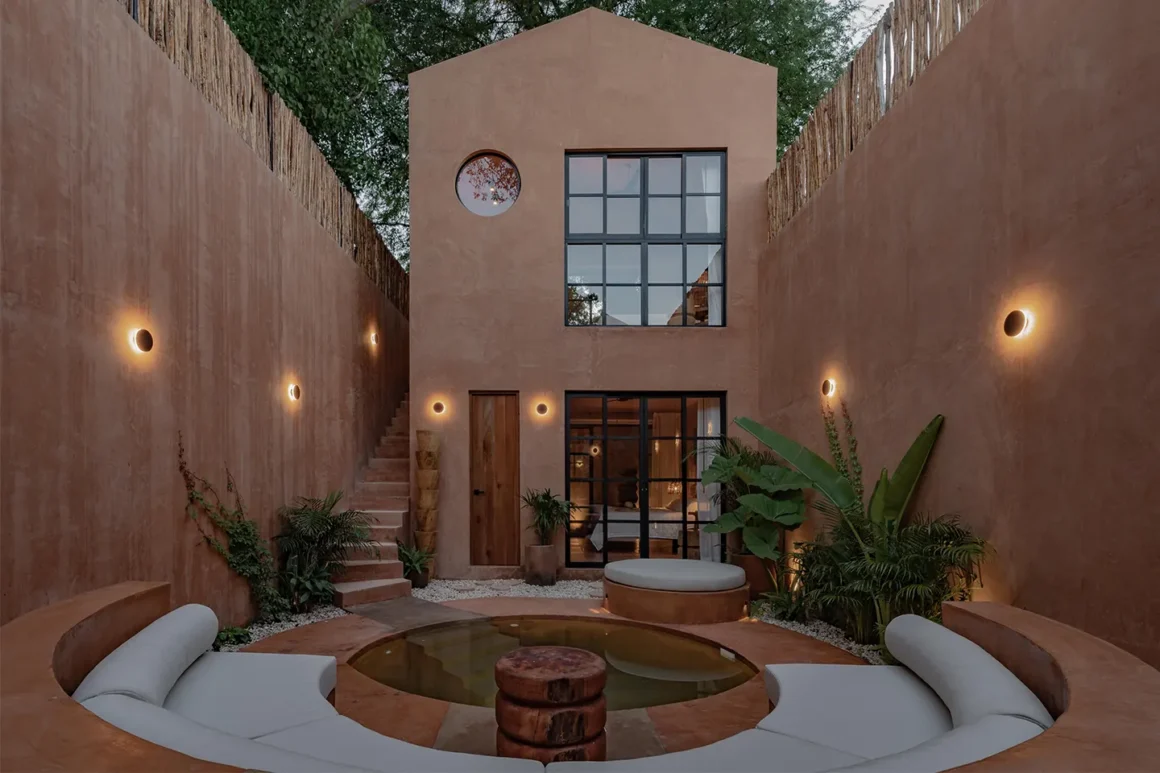 Casa Skoura di Enekén Studio, facciata in chukum arancione illuminata al tramonto