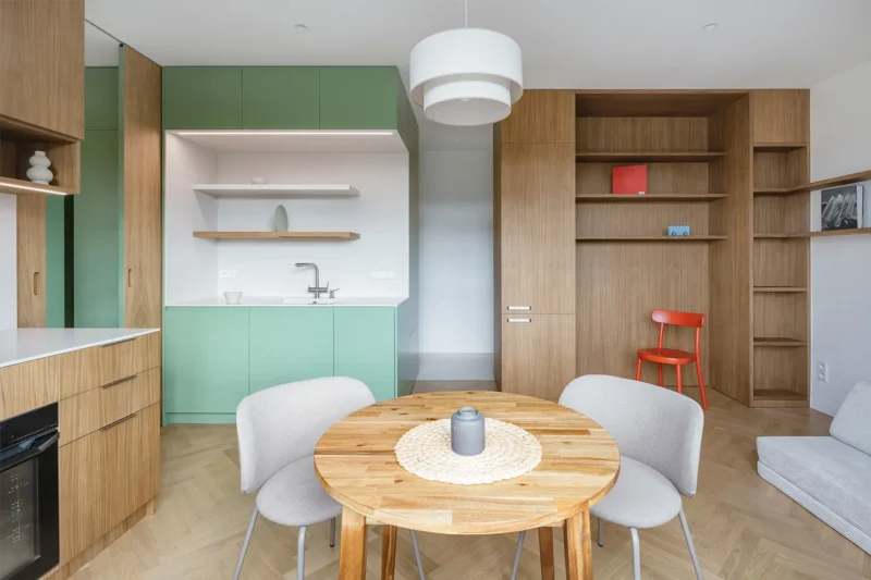 Il cubo verde che riorganizza lo spazio: dentro un piccolo appartamento a Praga 1 Cubo verde con cucina integrata e zona pranzo nel piccolo appartamento