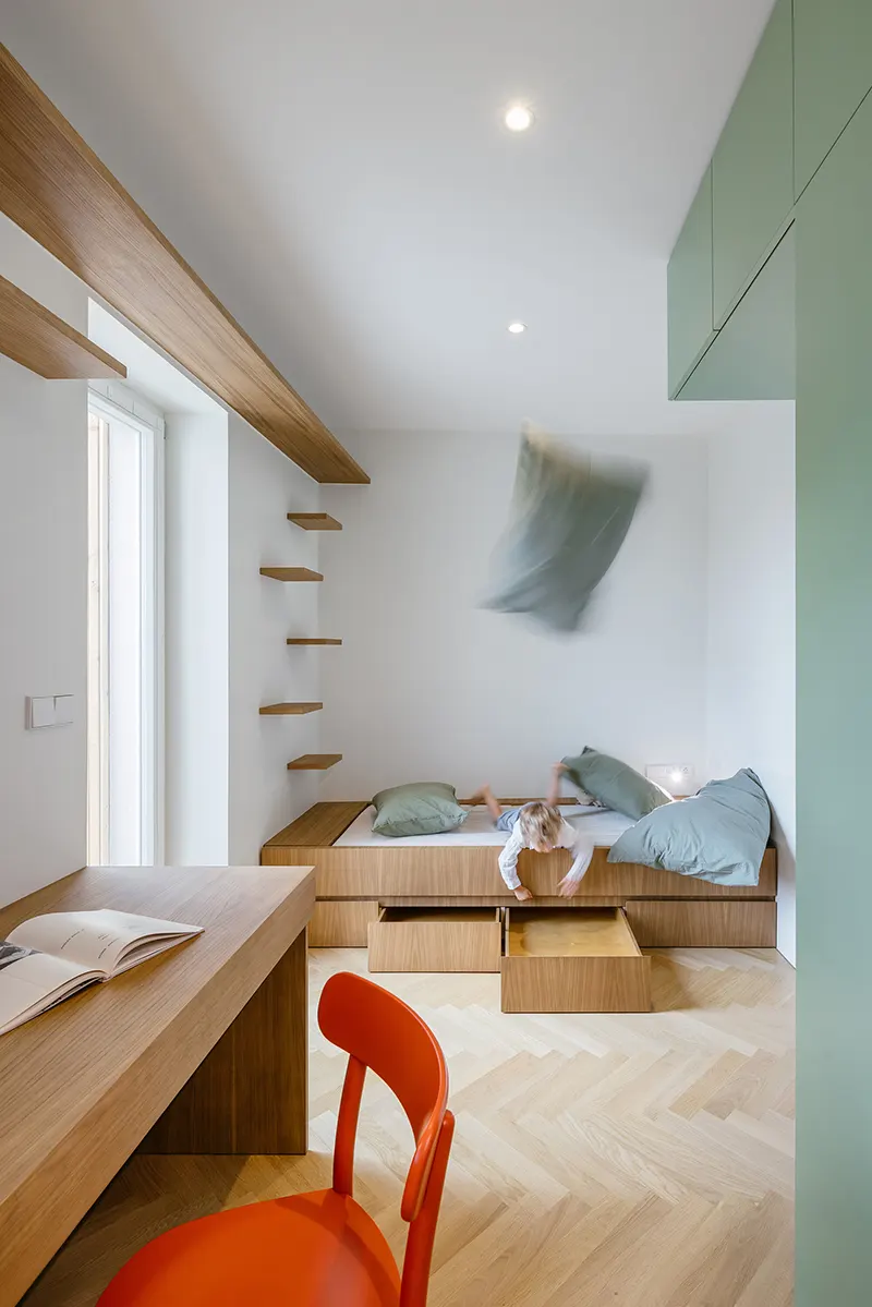 Il cubo verde che riorganizza lo spazio: dentro un piccolo appartamento a Praga 2 Letto con cassetti integrati nella stanza multifunzionale del piccolo appartamento