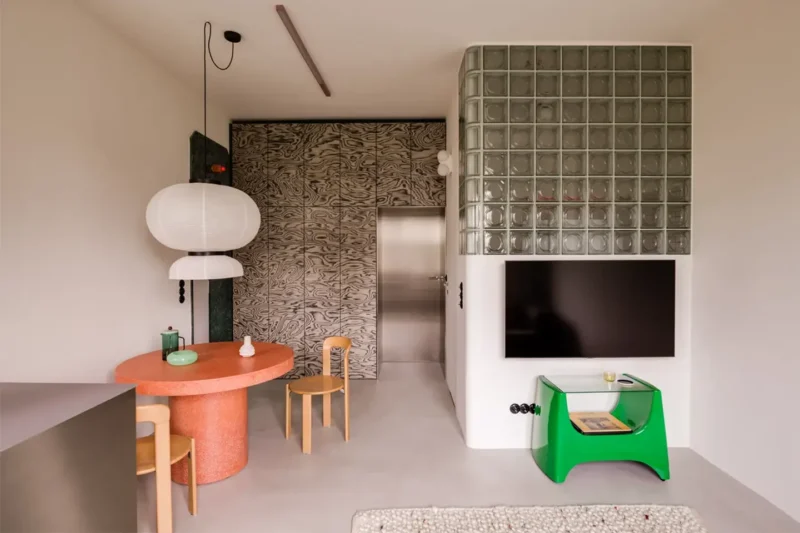Angolo in vetrocemento che incornicia la zona TV in un soggiorno dal design materico