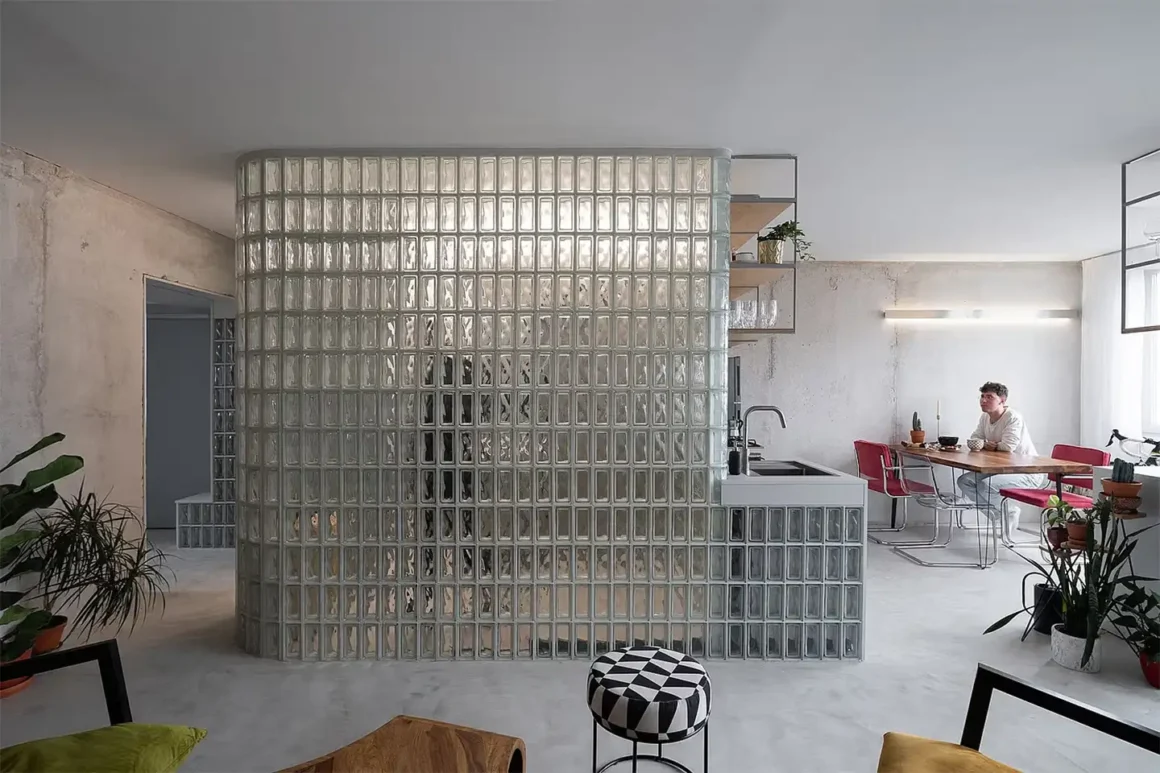 Parete curva in vetrocemento moderno che separa la cucina dal soggiorno in un loft dal design contemporaneo